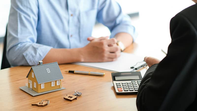 Mortgage Agent with customer signing documents to buy a new home