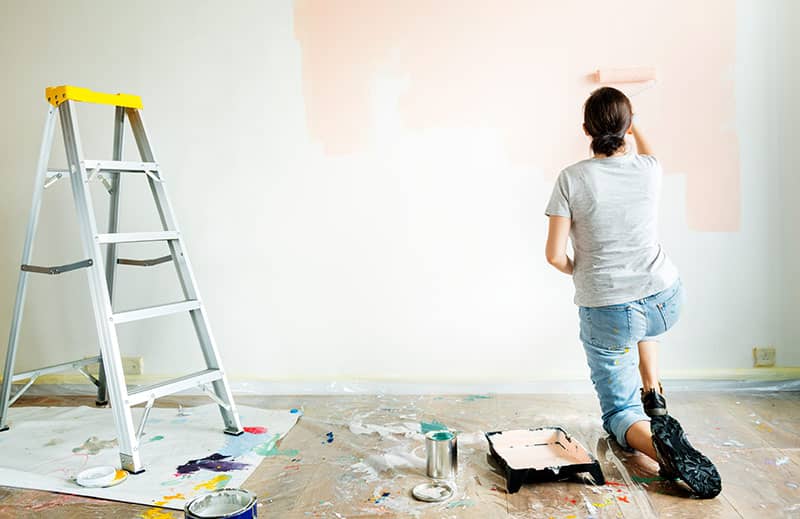 Woman painting and renovating her home before listing it