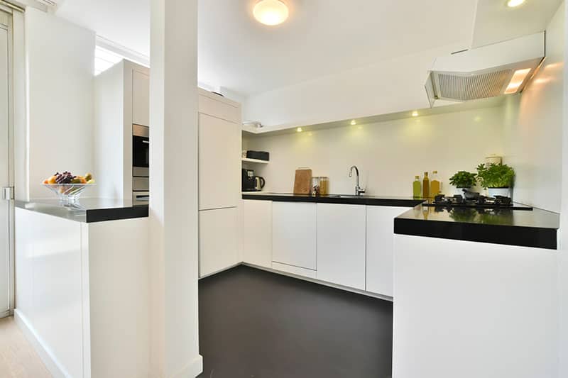 Finished white kitchen with glossy surfaces and clean open space